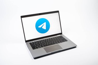 Prag, Çek Cumhuriyeti - 08 12 2025: Tek tip bir arkaplanda Telegram logosunu gösteren bir dizüstü bilgisayarın yukarıdan görünüşü. Telgraf hızlı ve güvenli iletiler için bir uygulamadır.