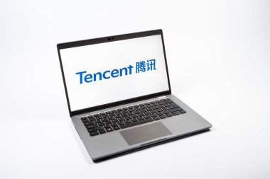 Prag, Çek Cumhuriyeti - 08 12 2025: Tek tip arkaplanda Tencent logosunu gösteren bir dizüstü bilgisayarın yukarıdan görünüşü. Tencent internet hizmetleri ve oyunlar sağlayan bir teknoloji şirketidir..
