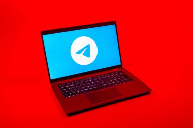 Prag, Çek Cumhuriyeti - 08 12 2025: Tek tip bir arkaplanda Telegram logosunu gösteren bir dizüstü bilgisayarın yukarıdan görünüşü. Telgraf hızlı ve güvenli iletiler için bir uygulamadır.