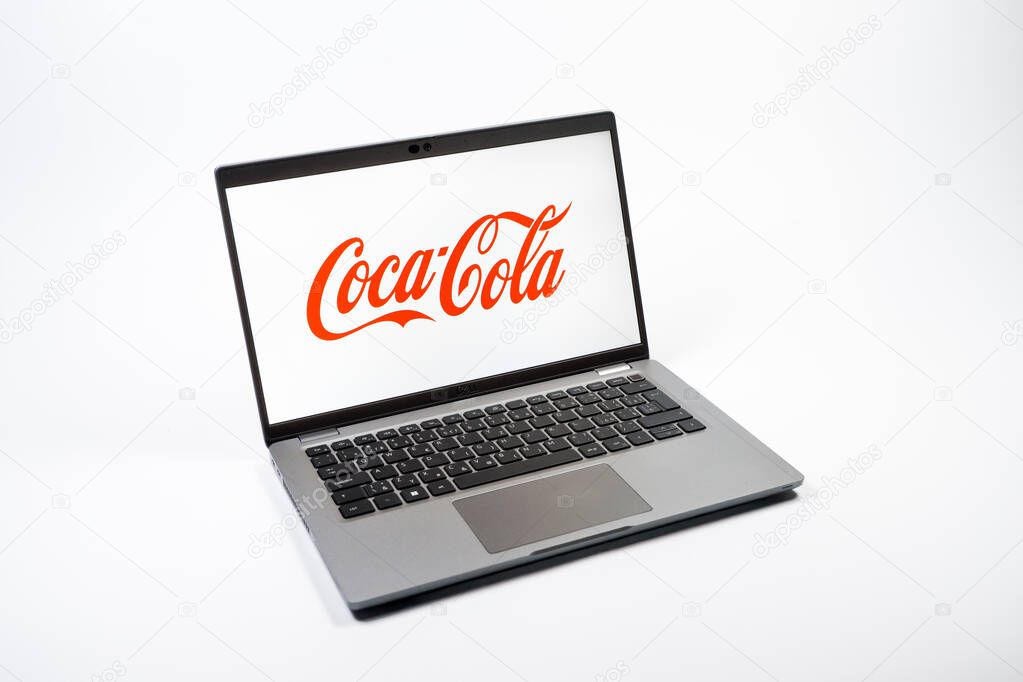 Prague, Czechia - 08 12 2025: A top-down view of a laptop on a uniform background displaying the Coca-Cola logo. Coca-Cola is a beverage company known for its soft drinks.