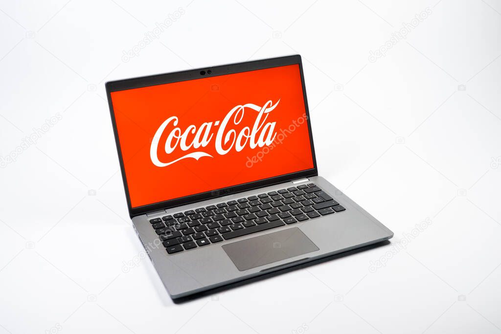 Prague, Czechia - 08 12 2025: A top-down view of a laptop on a uniform background displaying the Coca-Cola logo. Coca-Cola is a beverage company known for its soft drinks.