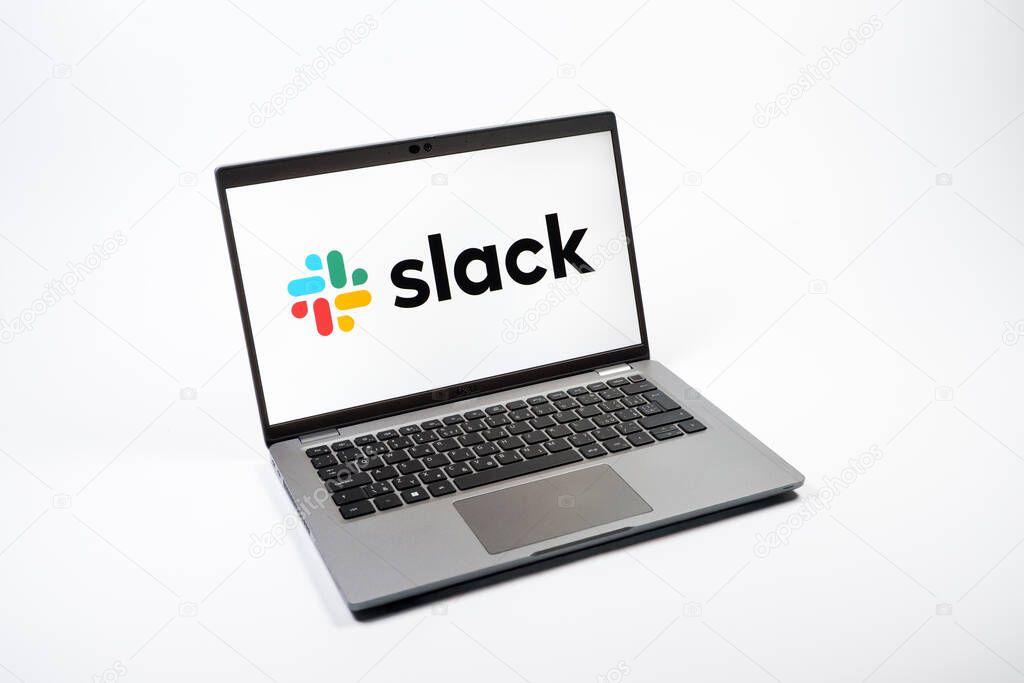 Prague, Czechia - 08 12 2025: A top-down view of a laptop on a uniform background displaying the Slack logo. Slack is a platform for team messaging and workplace communication.