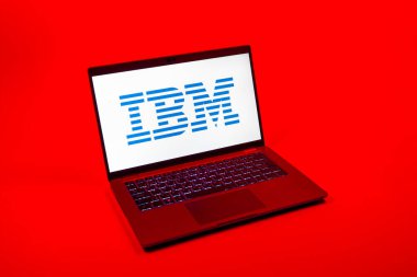 Prag, Çek Cumhuriyeti - 08 12 2025: Tek bir arkaplanda IBM logosunu gösteren bir dizüstü bilgisayarın yukarıdan aşağı görüntüsü. IBM yazılım, donanım ve danışmanlık sunan bir teknoloji şirketidir..