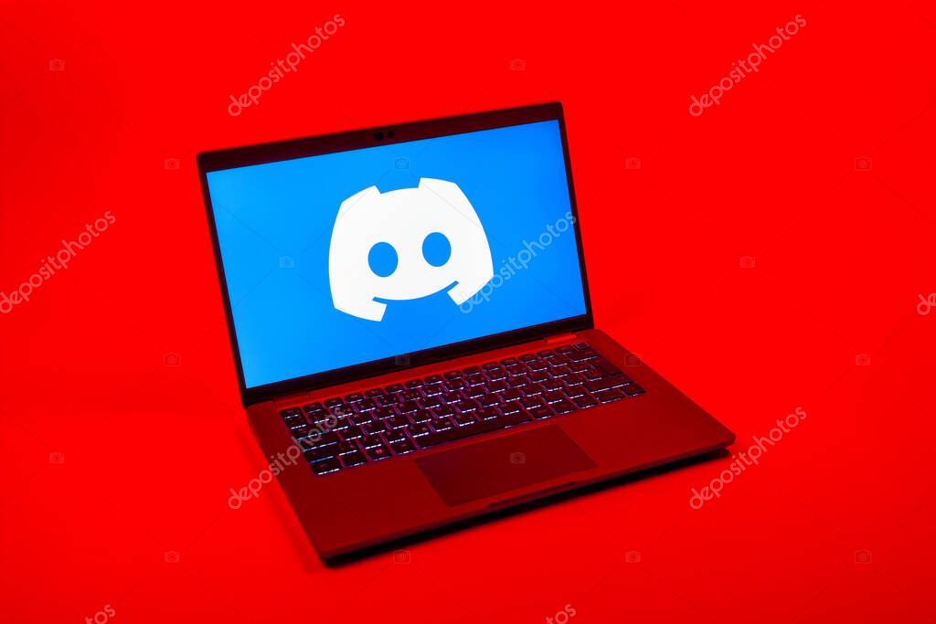 Prague, Czechia - 08 12 2025: A top-down view of a laptop on a uniform background displaying the Discord logo. Discord is a platform for voice, video, and text communication.