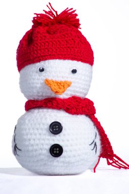 Kırmızı şapkalı ve eşarplı küçük, örülü bir kardan adam. Şapka iplikten yapılmıştır ve samimi ve sıcak bir havası vardır. Atkı da iplikten yapılmıştır ve parlak, göz alıcı kırmızı bir renktir.