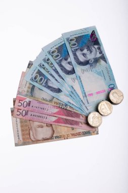 Minimalist beyaz bir arkaplan karşısında gösterilen 20, 50 ve 100 tabanlı Peru banknotlarının görsel olarak büyüleyici bir şekilde düzenlenmesi. Paraların canlı renkleri ve karmaşık tasarımları, Peru kültünü gözler önüne seriyor.