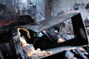 İçinde yeşil bir nesne olan siyah ve yanmış bir nesne. Nesne kırılmış ve içinde bir delik var. Sahne karanlık ve uğursuz.