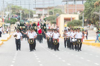 Kamuflaj üniformalı bir adam bir tüfek tutuyor ve yüzünde bir kafatası var. Askeri bir geçit töreninin bir parçası..
