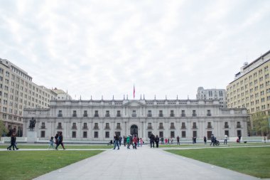 Santiago, Şili - 19 Eylül 2019: üzerinde bayrak olan büyük bir bina. İnsanlar binanın etrafında yürüyorlar. Gökyüzü bulutlu..