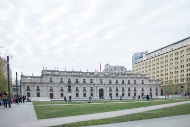 Santiago, Şili - 19 Eylül 2019: önünde bir adamın heykeli olan büyük bir bina. Bina çimenlik bir alanla çevrili ve birkaç kişi etrafta dolaşıyor..