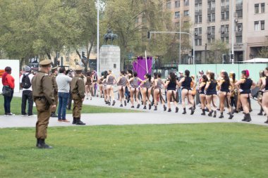 Santiago, Şili - 19 Eylül 2019: bir grup kadın üniformalı bir adamla birlikte caddede yürüyorlar. Sahne neşeli ve neşeli, çünkü kadınlar dar kıyafetler giyip dans ediyor ya da şarkı söylüyor gibi görünüyorlar..