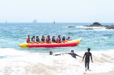 Üzüm bağı, Santiago, Şili - 10 Ocak 2020: Bir grup insan okyanusta sarı ve kırmızı bir sala biniyor. İnsanlar can yelekleri giyiyor ve gezinin tadını çıkarıyorlar.
