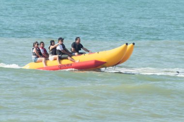 Zorritos, Tumbes, Peru - 24 Aralık 2023: Bir grup insan sarı ve kırmızı şişme bir sala biniyor. Sal suda hareket ediyor ve insanlar yolculuğun tadını çıkarıyor..