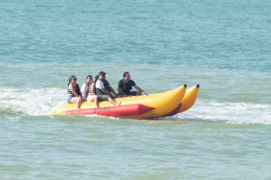 Zorritos, Tumbes, Peru - 24 Aralık 2023: Bir grup insan okyanusta iki sarı şişme sala biniyor. Sallar bir iple bağlandı ve insanlar bu yolculuğun tadını çıkarıyor..