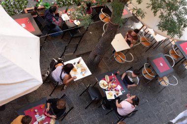 Santiago, Şili - 25 Ekim 2020: Bir grup insan bir restoranın dışında masalarda oturuyor. Masalar yiyecek ve içeceklerle dolu. Atmosfer hareketli ve sosyal, insanlar yemeklerini yiyor.