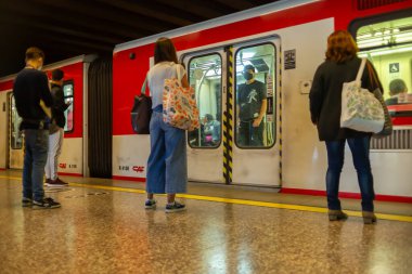 Santiago, Şili - 25 Ekim 2020: Bir grup insan trene binmek için bekliyor. İnsanlardan biri maske takıyor..