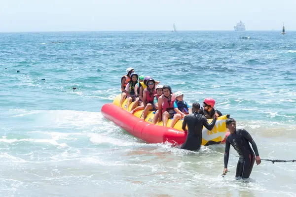 Üzüm bağı, Santiago, Şili - 10 Ocak 2020: Bir grup insan okyanusta sarı şişme bir sala biniyor. Öndeki adam dalgıç kıyafeti giyiyor..