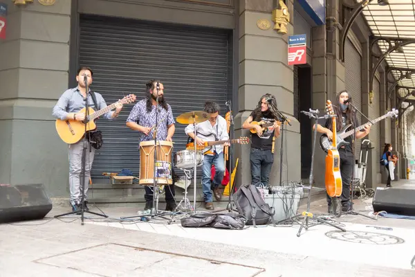 Santiago, Şili - 25 Ekim 2020: Sokak köşesinde enstrüman çalan bir grup müzisyen. Sahne canlı ve enerjik, müzisyenler seyirciler için gösteri yapıyor..