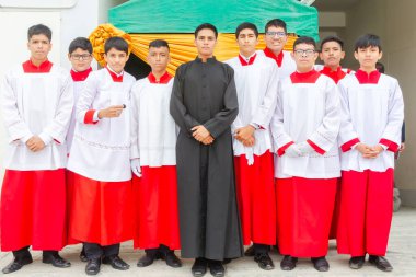 Tumbes, Tumbes, Peru 21-10-2023, Onaylama Ayini: Kırmızı ve beyaz cüppeli bir grup, ortada siyah cübbeli bir adamla birlikte ayakta duruyor. Grup arasında birlik ve beraberlik kavramı