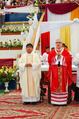Tumbes, Tumbes, Peru 21-10-2023, Onaylama Ayini: İki rahip kalabalığın önünde duruyor, biri kırmızı bornoz giyiyor. Sahne dini bir tören ya da toplantı gibi görünüyor.