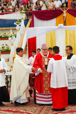 Tumbes, Tumbes, Peru 21-10-2023, Onaylama Ayini: bir rahip kırmızı cüppeli bir adamı kutsuyor. Rahip beyaz bir bornoz ve kırmızı bir şapka giyiyor.