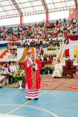 Tumbes, Tumbes, Peru 21-10-2023, Kuvvetlendirme Ayini: Kırmızı cüppeli bir adam kalabalığın önünde duruyor. O bir rahip ve bir konuşma yapıyor.
