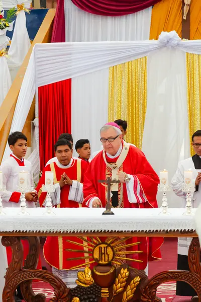 Tumbes, Tumbes, Peru 21-10-2023, Onaylama Ayini: Bir rahip elinde haç olan bir grup insanın önünde duruyor. Rahip kırmızı bir bornoz giyiyor ve mumlarla çevrili. Sahne kutsal ve dindardır.