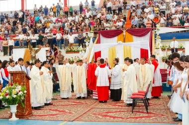 Tumbes, Tumbes, Peru 21-10-2023, Ayin Ayini: Beyaz cüppeli bir grup insan bir podyumun etrafında toplandı. Erkekler kırmızı ve beyaz giyiyor.
