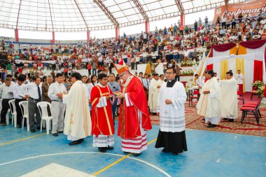 Tumbes, Tumbes, Peru 21-10-2023, Doğrulama Ayini: Kırmızı ve beyaz cüppeli bir grup adam toplandı. Bir adam diğerini kutsuyor.