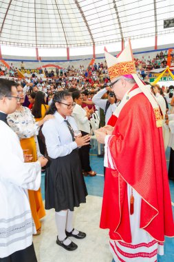Tumbes, Tumbes, Peru 21-10-2023, Doğrulama Ayini: Kırmızı cüppeli bir adam siyah etekli bir kadınla konuşuyor. Adam bir rahip ve kadın da bir öğrenci.