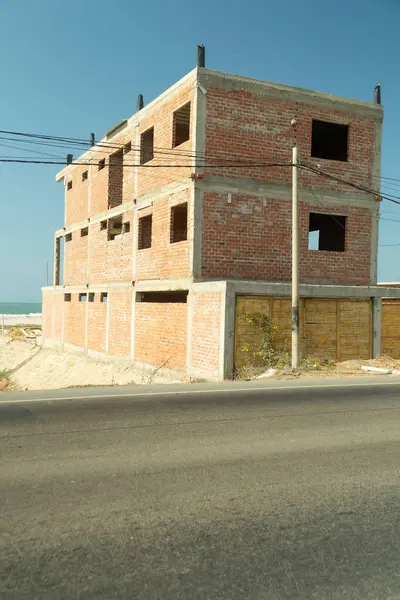 Bir sürü penceresi ve beton çatısı olan büyük bir tuğla bina. Bina boş ve hiç mobilyası yok.