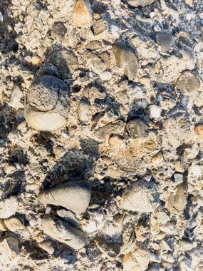 Birkaç çakıl taşı etrafa saçılmış bir kaya yığını. Kayaların boyutları ve şekilleri farklıdır ve çakıl taşları küçük ve yuvarlaktır. Sahne sakin ve huzurlu, kayalar gibi.