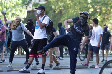 Santiago de Chile - Şili, 20-10-2019: Bir grup protestocu, siyah Adidas tişörtü giyen bir sokakta toplandı.
