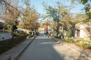 Santiago de Chile - Şili, 25-05-2021: Birkaç kişinin yürüdüğü bir sokak. Sokak boş ve yan tarafta bir çit var..