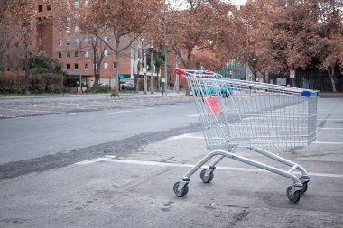 Santiago de Chile, Şili, 27-06-2021: Bir alışveriş arabası bir otoparkta duruyor. Araba boş ve üzerinde kırmızı bir etiket var. Otopark boş ve gökyüzü bulutlu..