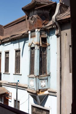 Santiago de Chile, Şili, 27-06-2021: Balkonu ve penceresi olan mavi bir bina. Pencere açık ve balkon boş..