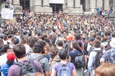 Santiago de Chile - Şili, 25-10-2019: Halka açık bir alanda büyük bir kalabalık toplandı. Sahne, insanların ortak bir amaç için bir araya geldiği heyecan ve enerjiden oluşur.