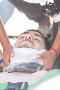 Santiago de Chile - Şili, 25-11-2019: Kafası bandajlı bir adama iki kişi yardım ediyor. Adam acı çekiyor ve savunmasız bir durumdaymış. Yaralı adam için bakım ve ilgi kavramı