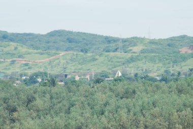Güzel, yemyeşil bir orman. Uzakta küçük bir köy var. Ağaçlar uzun ve yoğundur, sükunet ve sakinlik hissi yaratırlar. Köy küçük ve antika görünüyor.
