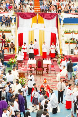 Tumbes, Tumbes, Peru 21-10-2023, Ayin Ayini: Dinsel bir tören için stadyumda büyük bir kalabalık toplandı. Etkinlik kırmızı ve beyaz perdeli ve büyük bir sunağı olan büyük bir odada gerçekleşiyor. Birkaç tane p var.