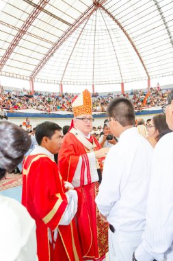 Tumbes, Tumbes, Peru 21-10-2023, Kuvvetlendirme Ayini: Şapkasında beyaz haç olan kırmızı cüppeli bir adam beyaz gömlekli bir adamla konuşuyor.