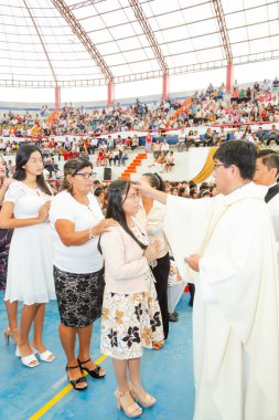 Tumbes, Tumbes, Peru 21-10-2023, Onaylama Ayini: Bir grup insan bir stadyumda toplandı, bir rahip bir kadını kutsuyor.