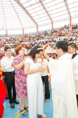 Tumbes, Tumbes, Peru 21-10-2023, Onaylama Ayini: Bir kadın, kalabalığın önünde bir rahip tarafından kutsanmaktadır. Rahip beyaz bir bornoz giyiyor ve kadın beyaz bir elbise giyiyor.