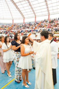 Tumbes, Tumbes, Peru 21-10-2023, Onaylama Ayini: Bir rahip beyaz elbiseli genç bir kadını kutsar. Kadın, insanların önünde rahip tarafından kutsandı.