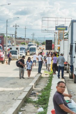 Tumbes, Tumbes, Peru 01-03-2025: Yürüyen ve ayakta duran insanlarla dolu bir cadde. Manzara canlı ve hareketli.