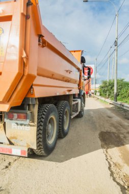 Tumbes, Tumbes, Peru 01-03-2025: Önünde kırmızı dur işareti olan bir çöp kamyonu yolda ilerliyor. Kamyon turuncu ve arkasında RMS harfleri var.