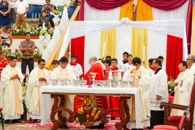 Tumbes, Tumbes, Peru 21-10-2023, Onaylama Töreni: Bir grup rahip kırmızı cüppeli bir adamın önlerinde durduğu bir masanın etrafında toplandı.