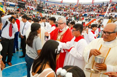 Tumbes, Tumbes, Peru 21-10-2023, Onaylama Ayini: Bir grup insan bir papazın etrafında toplandı, bazılarının elinde bardaklar vardı. Atmosfer kutlama ve neşe dolu görünüyor.