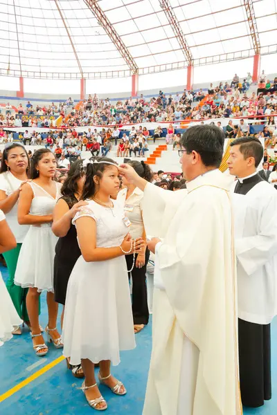 Tumbes, Tumbes, Peru 21-10-2023, Onaylama Ayini: Bir rahip beyaz elbiseli genç bir kızı kutsar. Kız rahip tarafından kutsandı.