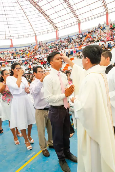 Tumbes, Tumbes, Peru 21-10-2023, Onaylama Ayini: Bir adam kalabalığın önünde bir rahip tarafından kutsanmaktadır. Rahip beyaz bir bornoz giyiyor ve kutsanan adam beyaz bir gömlek giyiyor.
